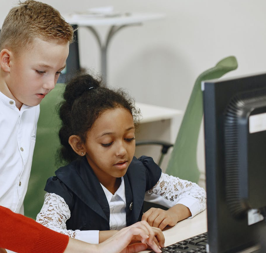 teacher helping students with computer problems