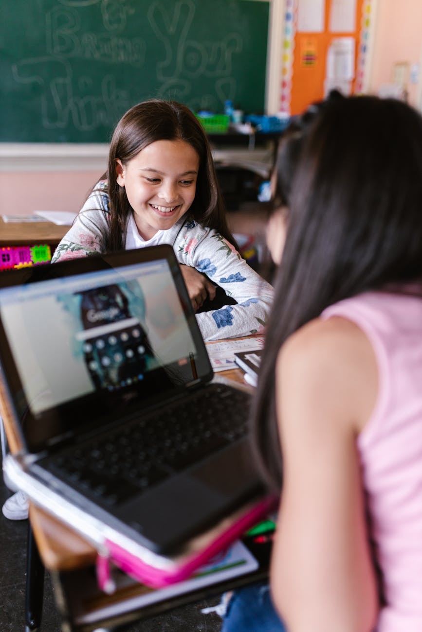 girl in pink sleeveless shirt using black laptop